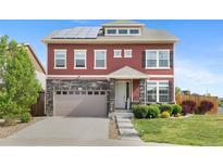 Charming two-story home with stone accents, solar panels, and a well-manicured lawn at 23593 E Chenango Pl, Aurora, CO 80016