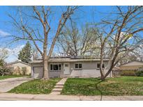Charming brick home featuring a well-maintained front yard and solar panels at 6026 Iris Way, Arvada, CO 80004
