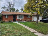 Charming brick ranch-style home with a well-maintained front yard and cozy outdoor seating area at 8660 De Soto St, Denver, CO 80229