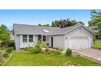 Charming single-story home featuring a well-maintained lawn, attached two-car garage and inviting curb appeal at 381 Mountain Cloud Cir, Highlands Ranch, CO 80126