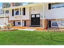 Inviting home entrance featuring a double-door entry, brick accents, and well-maintained landscaping at 3785 S Benton Way, Denver, CO 80235