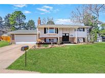 Charming two-story home with well-manicured lawn, attached garage, and inviting curb appeal on a sunny day at 3785 S Benton Way, Denver, CO 80235