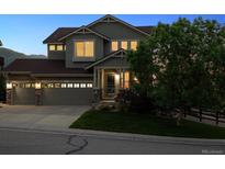 Charming two-story home with a well-manicured lawn, three-car garage, and inviting front porch at 10448 Kicking Horse Dr, Littleton, CO 80125