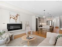 Bright, open living room features a fireplace, modern decor, and hardwood floors at 4917 Lowell Blvd # 105, Denver, CO 80221