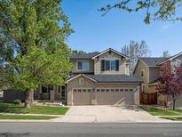 Charming two-story home featuring a three-car garage, brick accents, and a well-maintained front yard in a Gathering-friendly neighborhood at 6583 W Gould Dr, Littleton, CO 80123