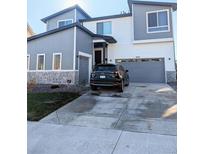Modern two-story home with a two-car garage and stylish gray and white exterior at 6332 E 142Nd Pl, Thornton, CO 80602