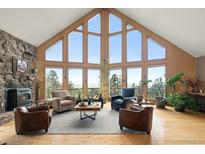 Bright living room with vaulted ceilings, large windows and mountain views at 13452 Riley Peak Rd, Conifer, CO 80433