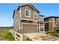 Two-story home with a two-car garage, neutral siding, and a well-maintained front yard with a white picket fence at 2511 Loon Ln, Castle Rock, CO 80104
