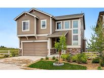 Charming home featuring neutral siding, stone accents, and an attached two car garage, complemented by a lawn at 2511 Loon Ln, Castle Rock, CO 80104