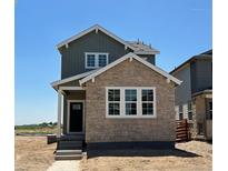 Charming two-story home with a combination of stone and siding exterior and a welcoming front porch at 3295 N Coolidge Way, Aurora, CO 80019