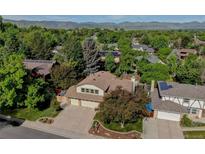 Beautiful home with a two car garage, mature trees and solar panels, with mountain views in the background at 8043 S Zephyr St, Littleton, CO 80128