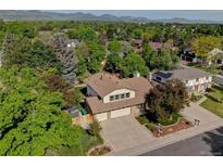 Inviting two-story home with a three-car garage, lush trees, and mountain views at 8043 S Zephyr St, Littleton, CO 80128