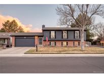 Charming two-story home with brick accents, complemented by a well-manicured front yard and mature tree at 18200 E Asbury Pl, Aurora, CO 80013