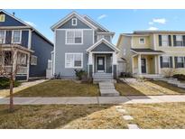 Charming two-story home with blue siding, complemented by a well-maintained lawn and inviting front entrance at 4540 Crestone Peak St, Brighton, CO 80601