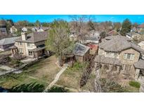 Charming brick home featuring a well-maintained lawn, mature trees, and a welcoming walkway at 451 Harrison St, Denver, CO 80206