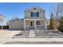 Charming two-story home with a welcoming front porch and well-maintained landscaping at 335 Tynan Dr, Erie, CO 80516