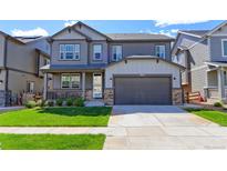 Charming two-story home with a well-manicured lawn and a two-car garage at 9835 Uravan St, Commerce City, CO 80022