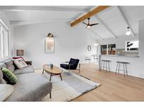 Inviting living space with vaulted ceilings and open floor plan to the kitchen area at 6133 Uno St, Arvada, CO 80003