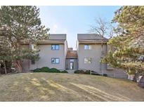 Inviting townhome featuring a well-manicured lawn and mature trees, showcasing its charming curb appeal at 23558 Pondview Pl # B, Golden, CO 80401