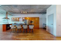 Modern kitchen with stainless steel appliances, breakfast bar, and ample cabinet space, perfect for culinary enthusiasts at 1401 Wewatta St # 808, Denver, CO 80202