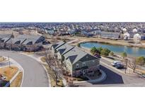 An aerial view of townhomes near a tranquil pond in a well-planned community at 12783 Leyden St # E, Thornton, CO 80602