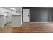 Open-concept living area featuring wood-look flooring and access to the kitchen at 8555 Fairmount Dr # D204, Denver, CO 80247