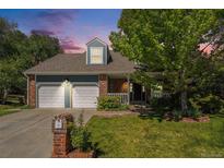 Charming two-story home featuring a well-manicured lawn, brick accents, and a two-car garage at 10247 W Roxbury Pl, Littleton, CO 80127