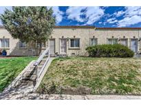 Charming row house with stucco exterior and small front yard and concrete stairway to the entrance at 3061 W 18Th Ave, Denver, CO 80204