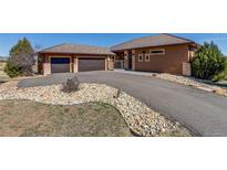 A beautiful stucco home with a two-car garage and a well-manicured, xeriscaped front yard at 7482 Sleeping Bear Trl, Littleton, CO 80125