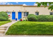 Charming townhome featuring a well-maintained lawn, blue front door, and manicured landscaping at 1800 Grove St, Denver, CO 80204