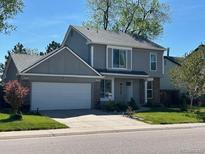 Charming two-story home with a well-manicured lawn, two-car garage, and traditional architectural details at 10064 Owens St, Broomfield, CO 80021
