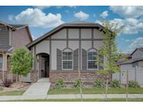 Charming home featuring stone accents, neutral colors, and a well-manicured front yard under a partly cloudy sky at 6612 N Ceylon St, Denver, CO 80249