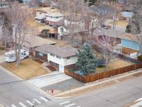 An elevated shot showcases a charming home with a well-kept yard in a peaceful, established neighborhood setting at 1492 S Dudley St, Lakewood, CO 80232