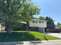 Charming two-story home with brick accents, green lawn, mature shade tree, and freshly painted trim at 1492 S Dudley St, Lakewood, CO 80232