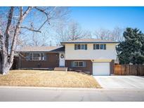 Charming two-story home with a brick facade, attached garage and mature trees at 1492 S Dudley St, Lakewood, CO 80232