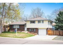 Charming home featuring a well-maintained lawn, brick accents, and a two-car garage at 1492 S Dudley St, Lakewood, CO 80232