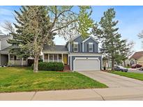 Charming two-story home features a well-manicured lawn, attached garage and delightful yellow front door at 8508 Vivian Ct, Arvada, CO 80005