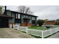 Charming two-story home with a well-manicured lawn and a classic white picket fence at 1528 Coronado Pkwy, Denver, CO 80229