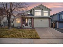 Inviting two-story home boasts a manicured lawn, two-car garage, and appealing curb appeal at 11613 W Coal Mine Dr, Littleton, CO 80127