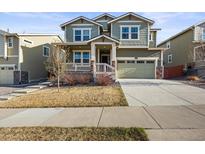 Inviting two-story home with a covered porch, attached garage, and well-maintained lawn in a suburban neighborhood at 14881 Chicago St, Parker, CO 80134