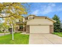 Charming two-story home featuring a front porch, brick accents, and an attached two-car garage at 20532 E Lake Cir, Centennial, CO 80016