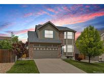 Two-story home with brick and siding, a two-car garage, and a well-manicured lawn at 5733 S Yakima Way, Aurora, CO 80015