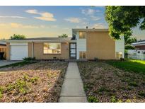 Charming brick home with an attached garage and low-maintenance front yard landscaping at 3055 Carson St, Aurora, CO 80011