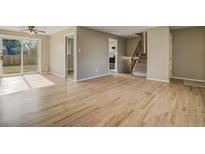 Bright living room features hardwood floors, sliding glass door, and stairway access to the upper level at 3055 Carson St, Aurora, CO 80011