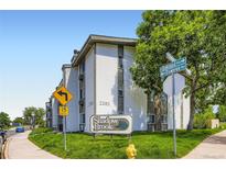 Exterior view of building with manicured lawn, mature trees and clear, blue skies at 2280 S Oswego Way # 104, Aurora, CO 80014