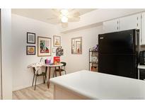 Bright kitchen featuring laminate flooring, stylish decorations, and modern black refrigerator at 5995 W Hampden Ave # 3H, Denver, CO 80227