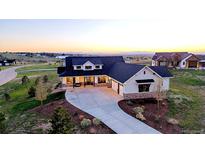 Stunning two-story home boasts a concrete driveway and beautiful landscaping against a serene sunset backdrop at 2741 Morning Run Ct, Franktown, CO 80116