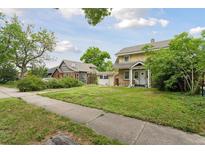 Charming two-story home featuring a well-maintained lawn and classic architectural details in a neighborhood setting at 1551 S University Blvd, Denver, CO 80210
