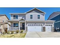 Charming two-story home featuring a covered front porch, three-car garage, and well-maintained landscaping at 17341 Red Cosmos Pt, Parker, CO 80134