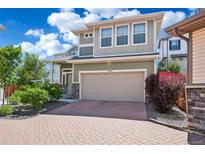 Charming two-story home featuring a two-car garage, beautiful brick driveway, and professionally landscaped yard at 18372 E 100Th Pl, Commerce City, CO 80022
